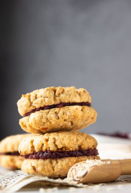 Kurutulmuş kızılcık ve portakal dolgulu vejetaryen yulaflı sandviç kurabiyeleri, seçici odaklanma. Çocuklar için sağlıklı kahvaltı ya da atıştırmalık.