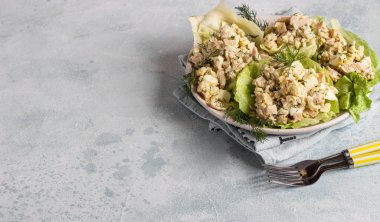 Yeşil marul yapraklarıyla servis edilen pirinç, yumurta, soğan ve dereotlu kalamar veya kalamar salatası. Lezzetli taze salata. Keto diyeti.