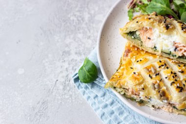 Somon, ıspanak ve yeşil marul yapraklarıyla servis edilen ricotta peynirli puf böreği. Puf böreğinde somon Wellington.