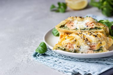 Somon, ıspanak ve yeşil marul yapraklarıyla servis edilen ricotta peynirli puf böreği. Puf böreğinde somon Wellington.