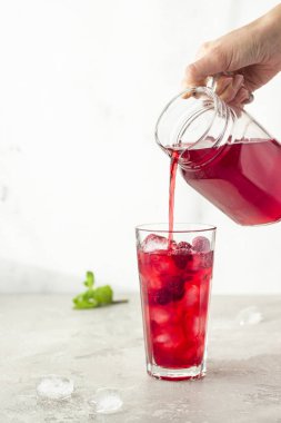 Buzlu ambar çayı (karkade, kırmızı kuş, Agua de flor de Jamaica) ya da açık gri arkaplanda ahududu ve nane aromalı limonata. 