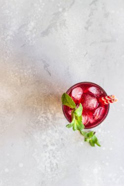 Buzlu ambar çayı (karkade, kırmızı kuş, Agua de flor de Jamaica) ya da açık gri arkaplanda ahududu ve nane aromalı limonata. 