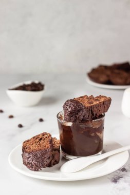 Geleneksel İtalyan ev yapımı bisküvi ya da çikolatalı cantuccini ve açık gri arka planda bir fincan kahve..