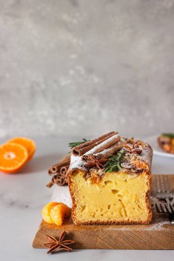 Taze portakal ya da mandalinalı yoğurtlu tarçınlı kek (tarçın ve anason) ve şeker tozu. Açık gri arkaplanda ev yapımı kek.