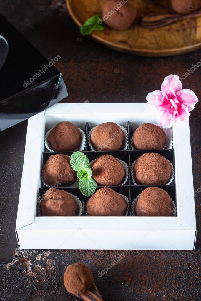 Gift box of delicious chocolate truffles with raw cocoa powder and mint. Gift for Valentine's Day.
