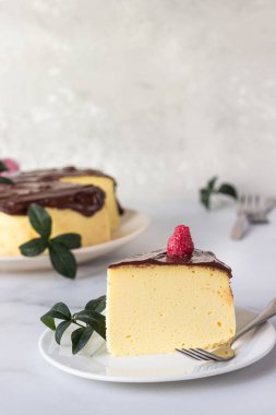 Seramik tabakta çikolata jöleli Japon pamuklu sufle peynirli keki. Açık gri arkaplan.