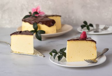 Seramik tabakta çikolata jöleli Japon pamuklu sufle peynirli keki. Açık gri arkaplan.