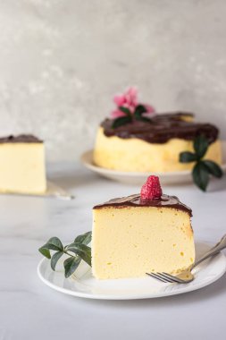 Seramik tabakta çikolata jöleli Japon pamuklu sufle peynirli keki. Açık gri arkaplan.