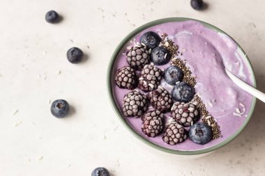 Üzümlü meyve suyu kasesi, böğürtlen, chia tohumu ve hindistan cevizi gevreği. Sağlıklı kahvaltı meyve suyu kasesi.
