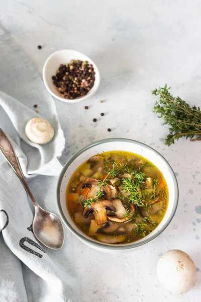 Homemade thick vegetarian mushroom soup with barley and vegetables with herbs in a ceramic bowl on a light grey stone background. Delicious cozy first course, comfort food. — Stock Image Homemade Thick Vegetarian Mushroom Soup Barley Vegetables Herbs Ceramic Bowl Stock Photo