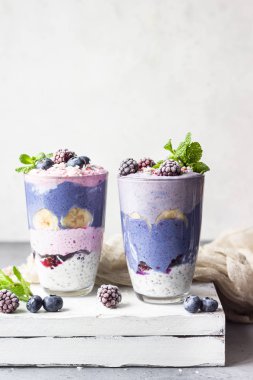 Farklı böğürtlenlerden, meyvelerden ve bardaktaki chia pudinginden yapılmış detoks katmanlı smoothie. Vejetaryen tatlı. Sağlıklı vejetaryen kahvaltısı, diyet, kilo kaybı..
