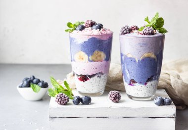 Farklı böğürtlenlerden, meyvelerden ve bardaktaki chia pudinginden yapılmış detoks katmanlı smoothie. Vejetaryen tatlı. Sağlıklı vejetaryen kahvaltısı, diyet, kilo kaybı..