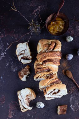 Ev yapımı tarçınlı babka dilimleri ya da girdaplı brioche ekmeği. Tarçınlı ekmek. Povitica: Geleneksel Polonya tatlı ekmeği. Eski kahverengi beton arka plan.