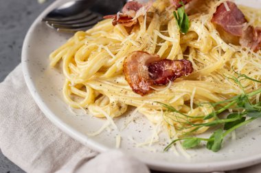 Carbonara makarna, pastırmalı spagetti, yumurta, parmesan peyniri ve krema sosu seramik tabakta. Geleneksel İtalyan mutfağı. Carbonara soslu makarna..