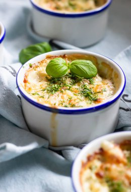Şampiyonlar, tavuk filetosu, porselen seramik formlarda peynir ve fesleğen ile sıcak meze (Julien). Yaklaş, seçici odaklanma. 