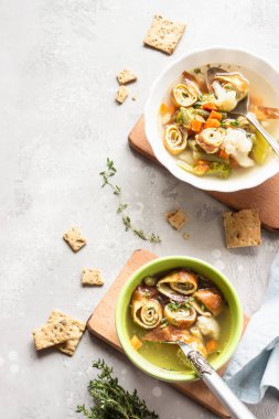 Açık gri arka planda yumurta krepli sebze çorbası. Geleneksel Alman Flaedlesuppe ve Avusturya Frittatensuppe. 