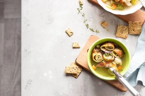 Vegetable soup with egg pancakes on light grey background. Traditional German Flaedlesuppe and Austrian Frittatensuppe. — Stock Image Vegetable Soup Egg Pancakes Light Grey Background Traditional German Flaedlesuppe Royalty Free Stock Photos