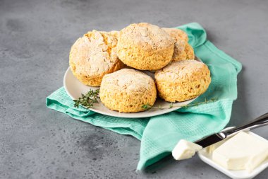 Ev yapımı peynirli çörekler, çörekler ve gri seramik tabakta kekik.. 