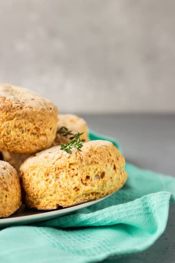 Ev yapımı peynirli çörekler, çörekler ve gri seramik tabakta kekik.. 