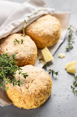 Peynirli, kekikli ve peynirli ev yapımı çöreklerle bez çanta. Taze pişmiş lezzetli İngiliz çörekleri. Gri taş arka plan.
