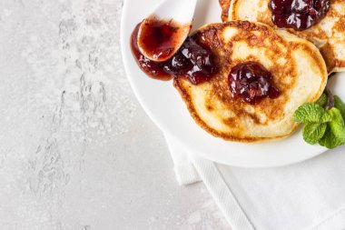 Kırmızı böğürtlen reçeli ve nane şekerli krepler, açık gri taş arka plan. Amerikan mutfağı. Kahvaltı.. 