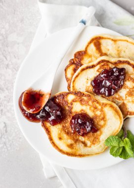 Kırmızı böğürtlen reçeli ve nane şekerli krepler, açık gri taş arka plan. Amerikan mutfağı. Kahvaltı.. 