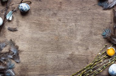 Bıldırcın yumurtalı, söğüt dallı ve tüylü eski ahşap tepsi. Paskalya arkaplanı, doku. Metin için alanı kopyala.