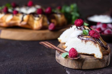 Süzme peynir fırınlanmış puding ya da çikolata jöleli güveç ahududu ve nane ile süslenmiş. Karanlık ruh hali fotoğrafı, kahverengi taş arka plan..