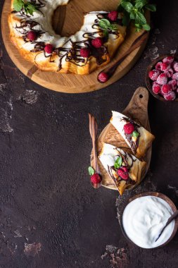 Süzme peynir fırınlanmış puding ya da çikolata jöleli güveç ahududu ve nane ile süslenmiş. Karanlık ruh hali fotoğrafı, kahverengi taş arka plan..