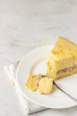 Bir dilim balkabaklı cheesecake ve karamel soslu açık gri taş zemin. Seçici odak. 