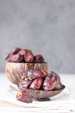 Hindistancevizi kabuğu ve organik medijool açık gri beton arka planda tarihler. Seçici odak, boşluğu kopyala.