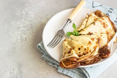 Krep, pembe yoğurtlu ince krep, reçel ve naneli bal seramik tabakta.. 