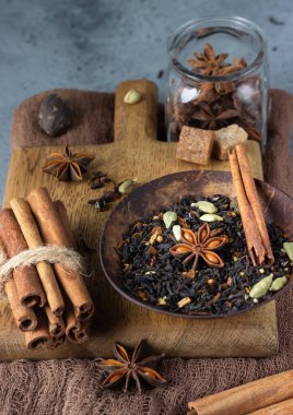 Sıcak baharatlı çay ya da Hint masala çayı - tarçın, anason, kakule, hindistan cevizi, biber ve esmer şeker. Gri taş arka plan.