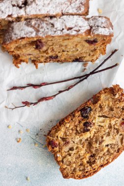 Baharatlı elma, fındık ve kurutulmuş yaban mersinli kek. Kağıt üzerinde pudra şekerle süslenmiş..