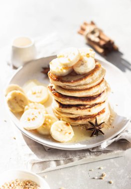 Muzlu krep, bal ve seramik tabakta fındık, güneşli gölgeli masa yüzeyi. Doğal ışık ve gölgeler yiyecek fotoğrafçılığı konsepti. Kahvaltı..
