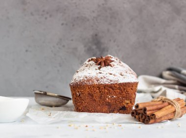 Baharatlı elma, fındık ve kurutulmuş yaban mersinli kek. Kağıt üzerinde pudra şekerle süslenmiş..