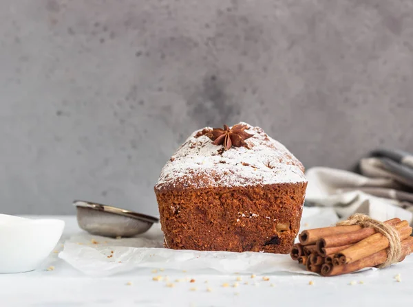 Baharatlı elma, fındık ve kurutulmuş yaban mersinli kek. Kağıt üzerinde pudra şekerle süslenmiş..