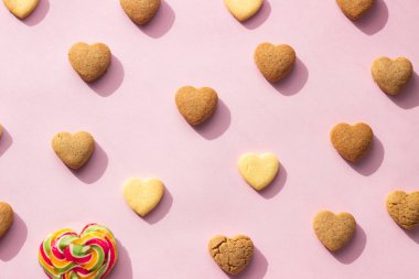 Düz kompozisyon ve pembe kağıtta kalp şeklinde kurabiyeler. Kurabiye deseni, en düşük kompozisyon. Aşk konsepti. Romantik tebrik..