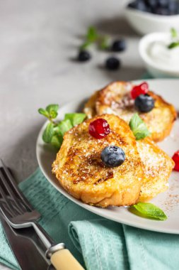 Yaban mersinli Fransız tostları, kurutulmuş kiraz ve nane şekeri, açık gri arka plan. Tatlı kahvaltı.. 