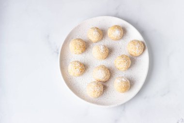 Geleneksel Hint festivali tatlıları (Laddoo veya Laddu) seramik tabakta hindistan cevizi taneleri, hafif arka plan, seçici odak. Hindistan 'da popüler çay saati tatlı atıştırmalığı..