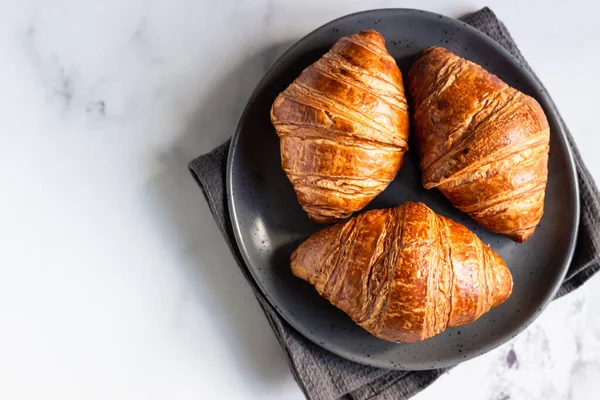 Três Deliciosos Croissants Frescos Uma Placa Cerâmica Fundo Cinza Claro — Fotografia de Stock