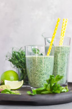 Yeşil smoothie ile sağlıklı kahvaltı bardakta kibrit tozu çayı ve ahşap tepside malzemeler. Detoks, diyet, sağlıklı, vejetaryen gıda konsepti.