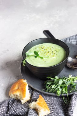 Avokado ile vegan kremalı çorba ve mikro yeşillik ve ekmekle servis edilen ıspanak. Diyet gıda konsepti. Vejetaryen ve vejetaryen yemekleri. 