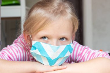 Pamuk tıbbi koruma maskesi takmış Avrupalı bir kızın portresi. Sağlık ve tıbbi konsept. Coronavirus Covid-19 konsepti. Önleme salgını.