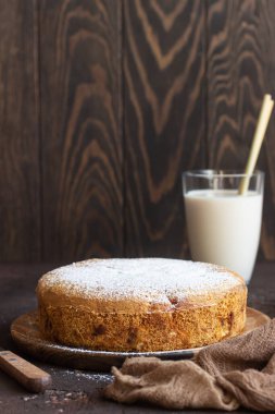 Koyu kahverengi arka planda ev yapımı lezzetli sünger ya da yumuşak kek. Taze pişmiş Sharlotka, sünger elmalı kek..