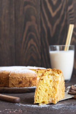 Koyu kahverengi arka planda ev yapımı lezzetli sünger ya da yumuşak kek. Taze pişmiş Sharlotka, sünger elmalı kek..