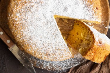 Koyu kahverengi arka planda ev yapımı lezzetli sünger ya da yumuşak kek. Taze pişmiş Sharlotka, sünger elmalı kek..