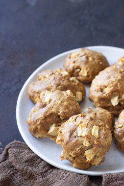 Seramik tabakta yumuşak ve yumuşak elma bisküvileri, koyu beton arka plan. Çocuklar için tatlı ya da kahvaltı, tatlı atıştırmalık. Seçici odak.