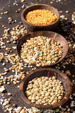 Beyaz pirinç ve farklı türde mercimek, koyu kahverengi beton arka plan. Tarım ürünü kavramı.