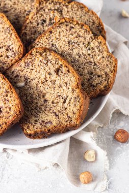 Seramik tabakta dilimlenmiş fındık ve muzlu kek. Seçici odak.